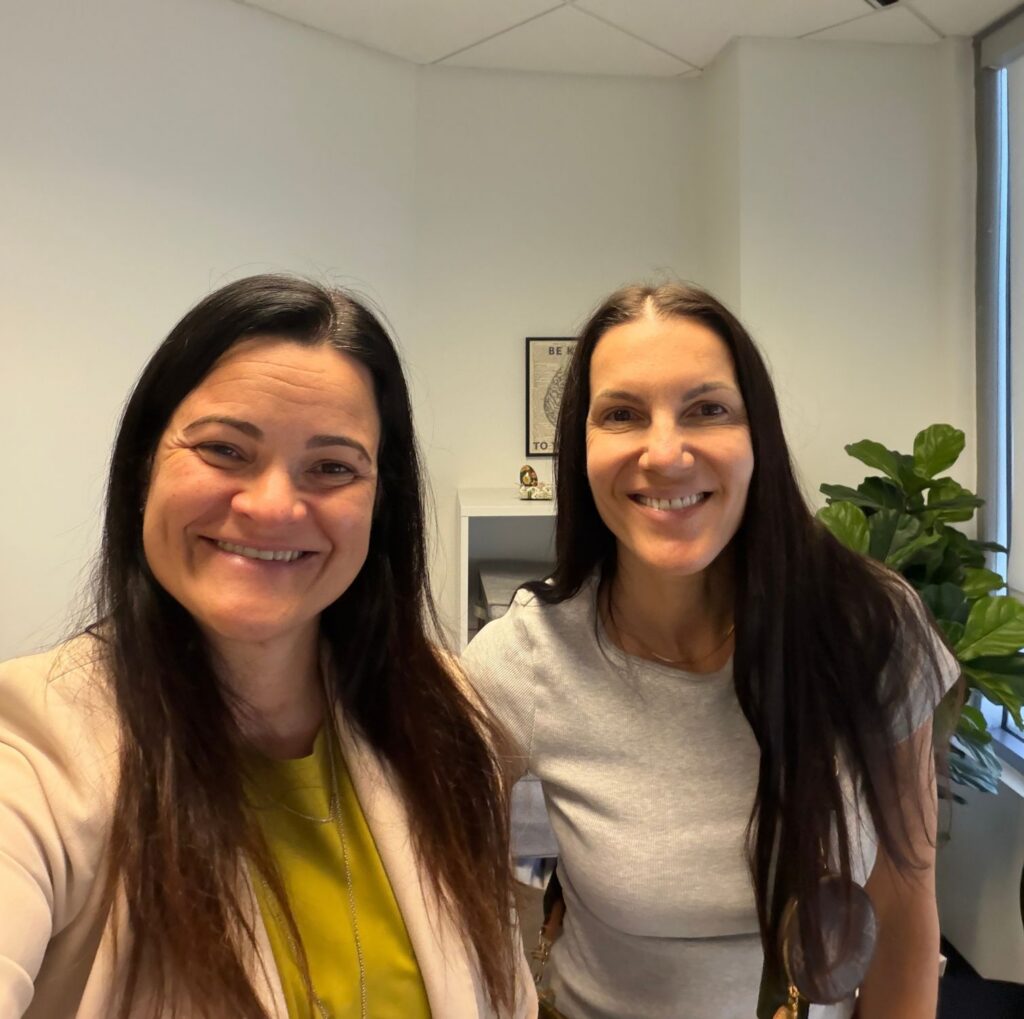 Two smiling women in a bright San Diego office